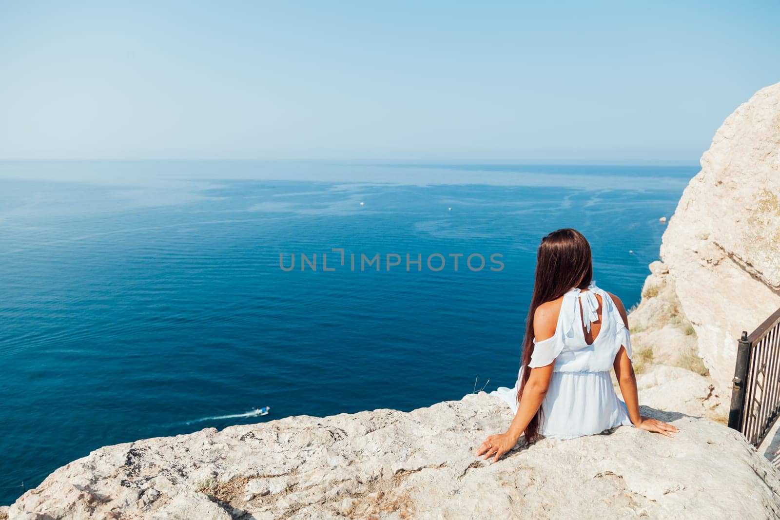 portrait of a woman with long hair in a dress on a cliff cliff by the sea