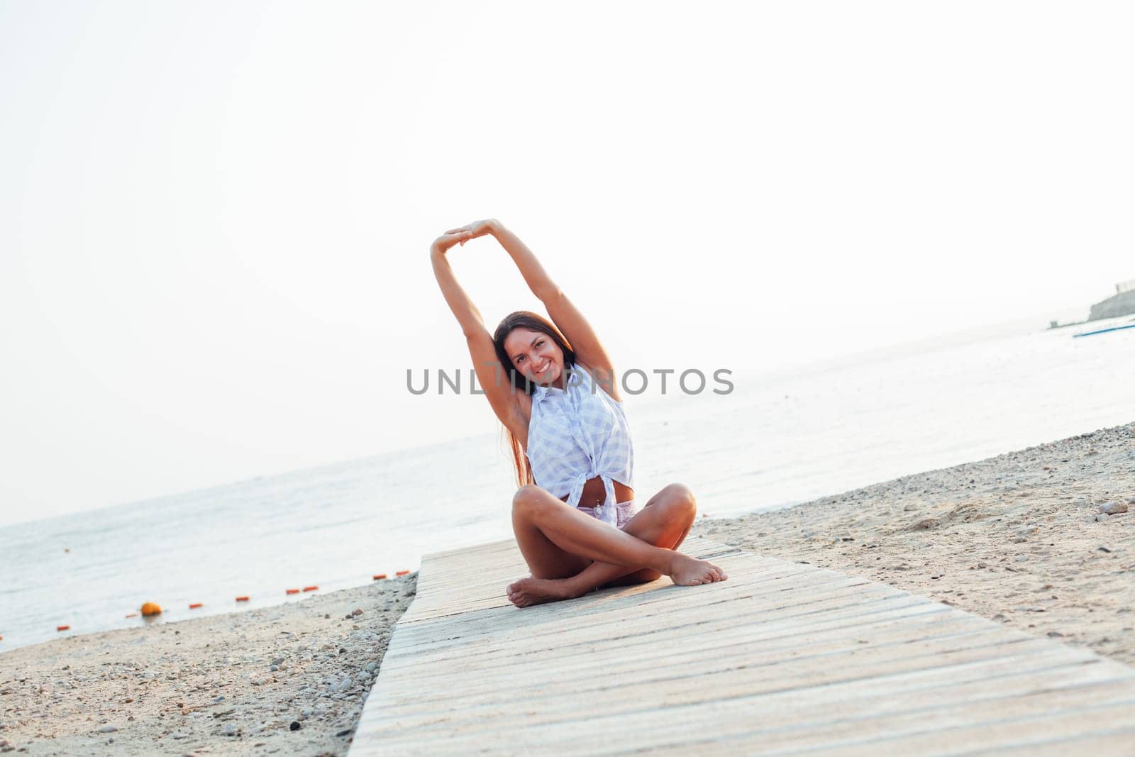 portrait of a beautiful woman with long hair on the beach by the sea by Simakov