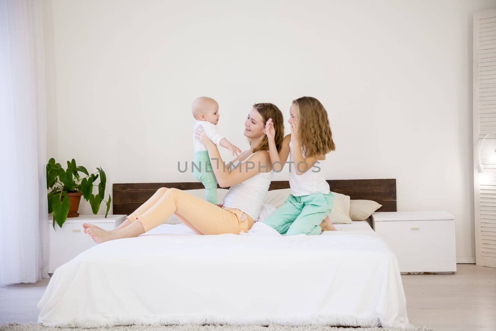 three little girls sisters in the bedroom on the bed by Simakov