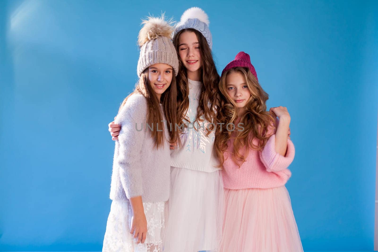 Three beautiful fashionable girl girlfriends in a hat cold winter snow by Simakov