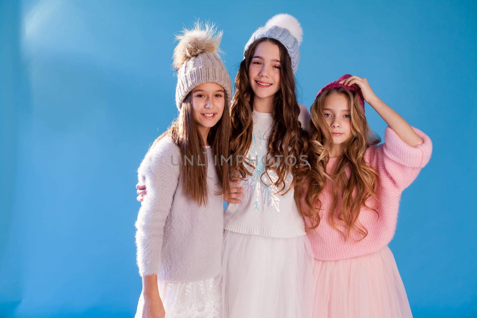 Three beautiful fashionable girl girlfriends in a hat cold winter snow by Simakov