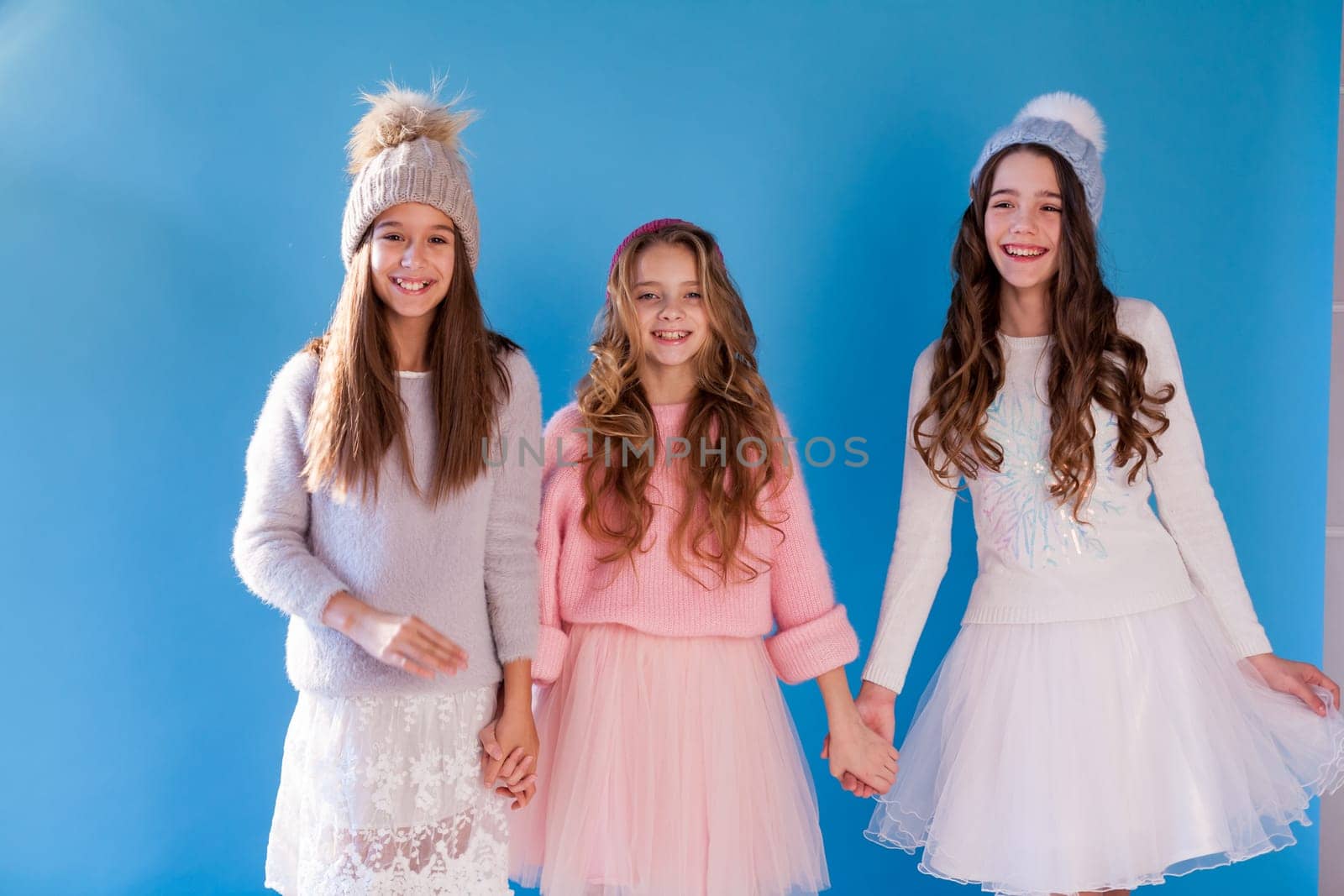 Three beautiful girl girlfriends in a hat cold winter snow