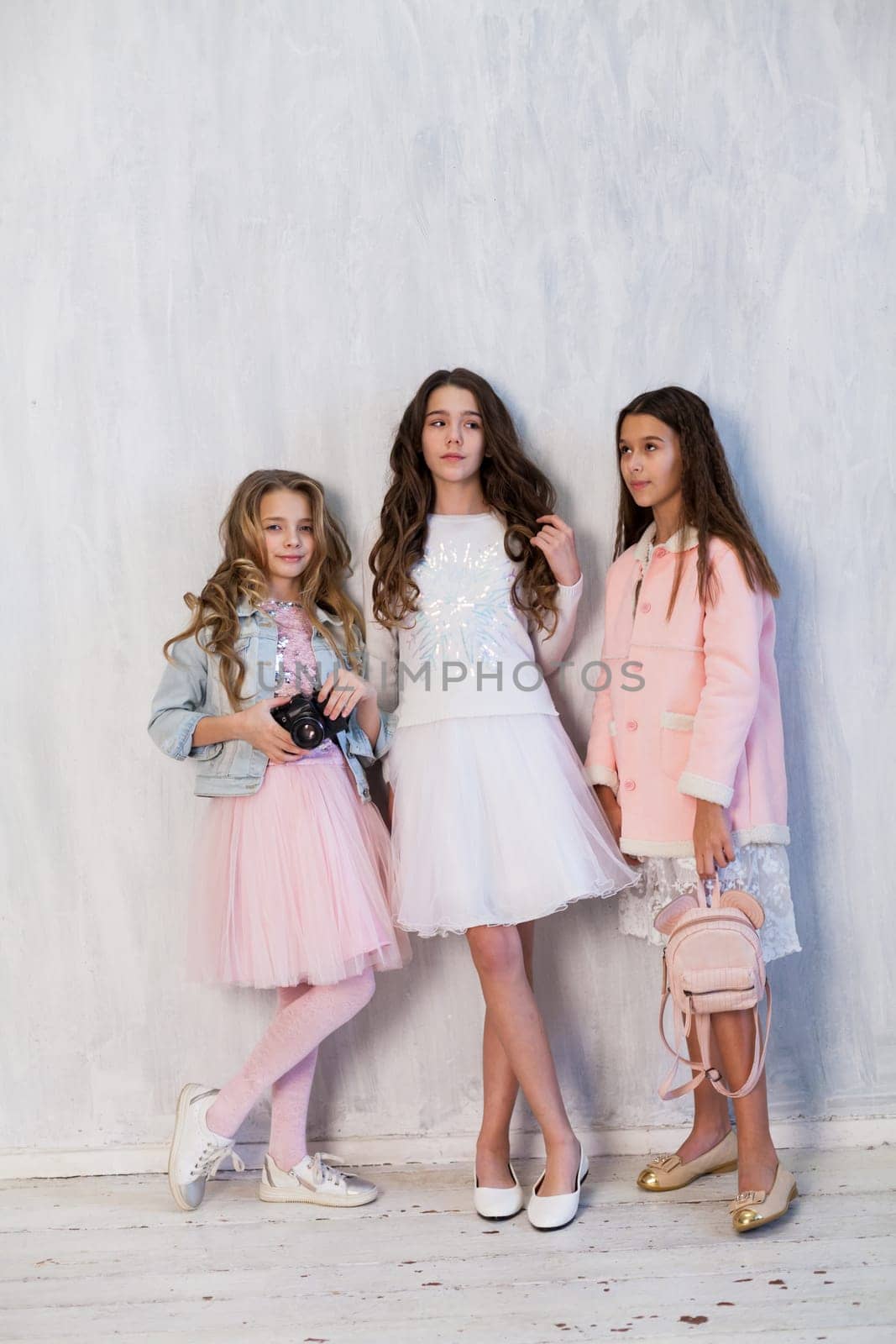 Two beautiful fashionable girls girlfriend in pink and white dresses at the photo shoot