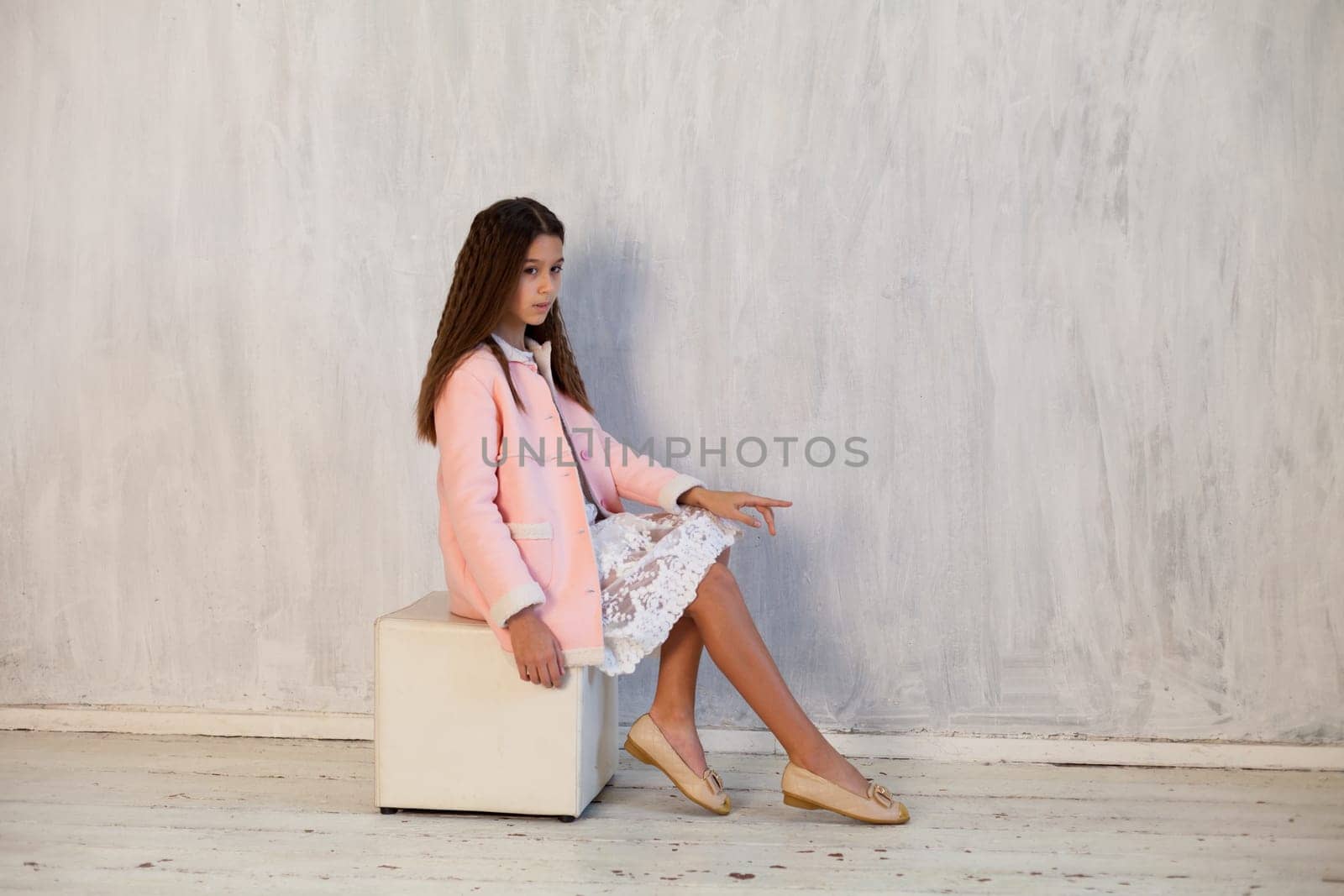 Portrait of a beautiful fashionable girl in a pink truncheon and a white dress