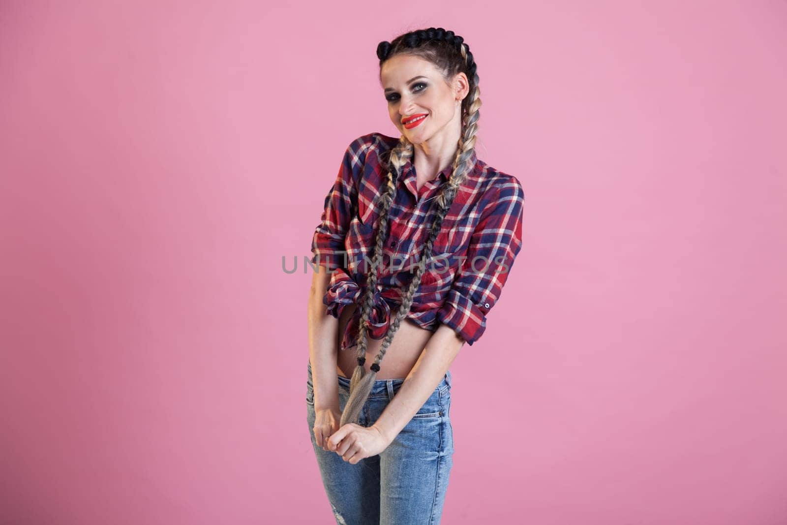 Portrait of a beautiful fashionable woman with braids in a moilshirt and jeans