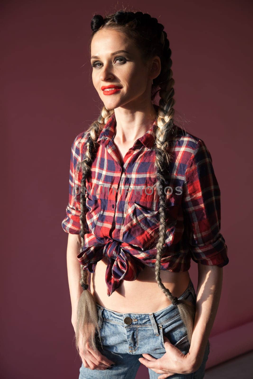 Portrait of a beautiful fashionable woman with braids in a moilshirt and jeans