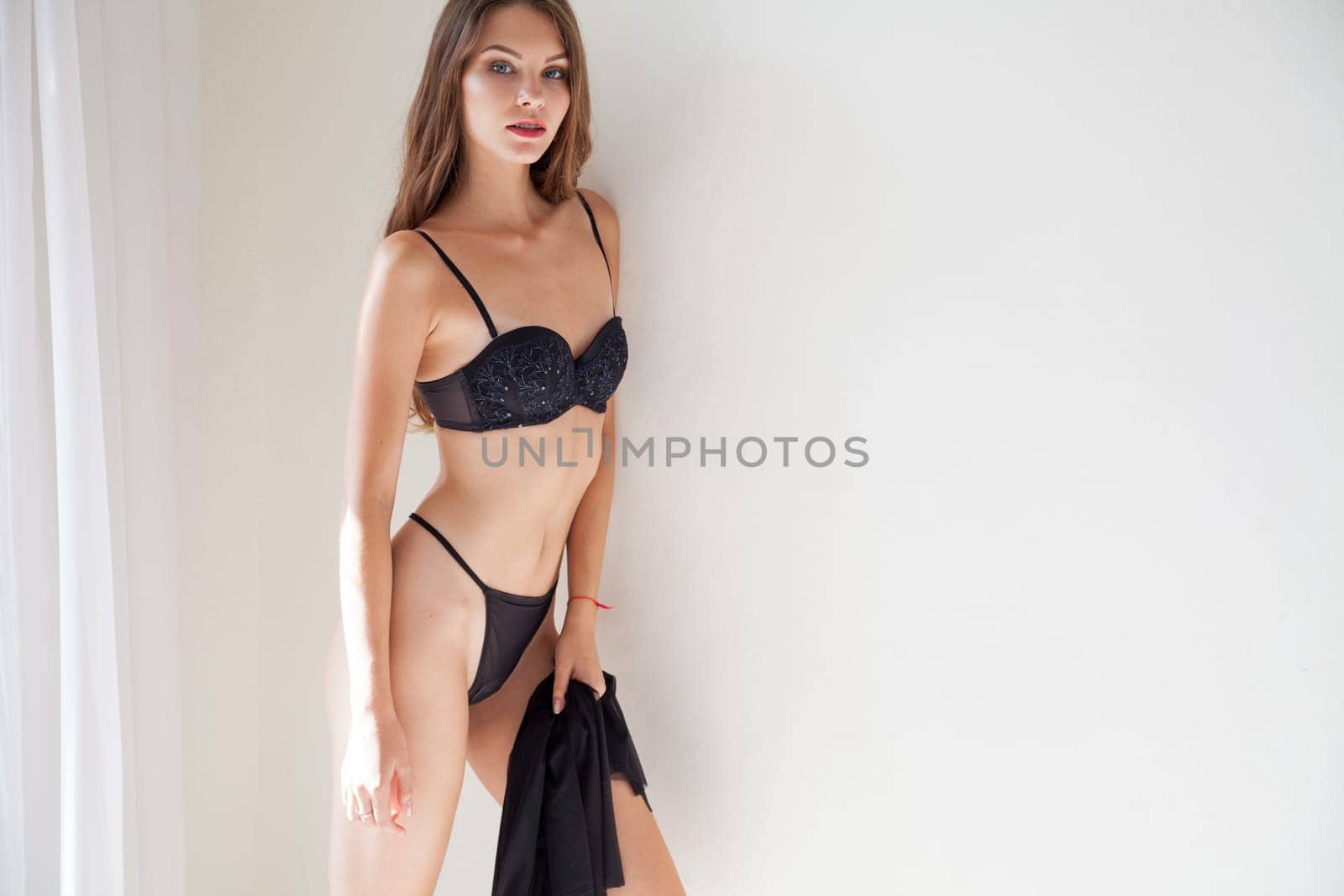 Portrait of a beautiful fashionable woman in lingerie at home by Simakov