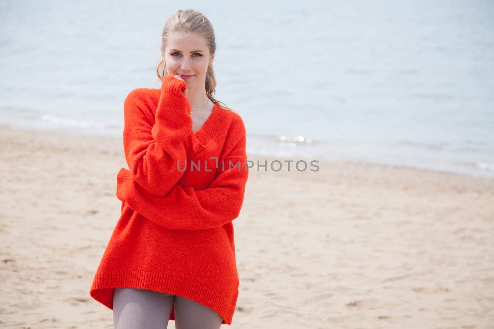 Beautiful woman walks alone on the beach by the sea