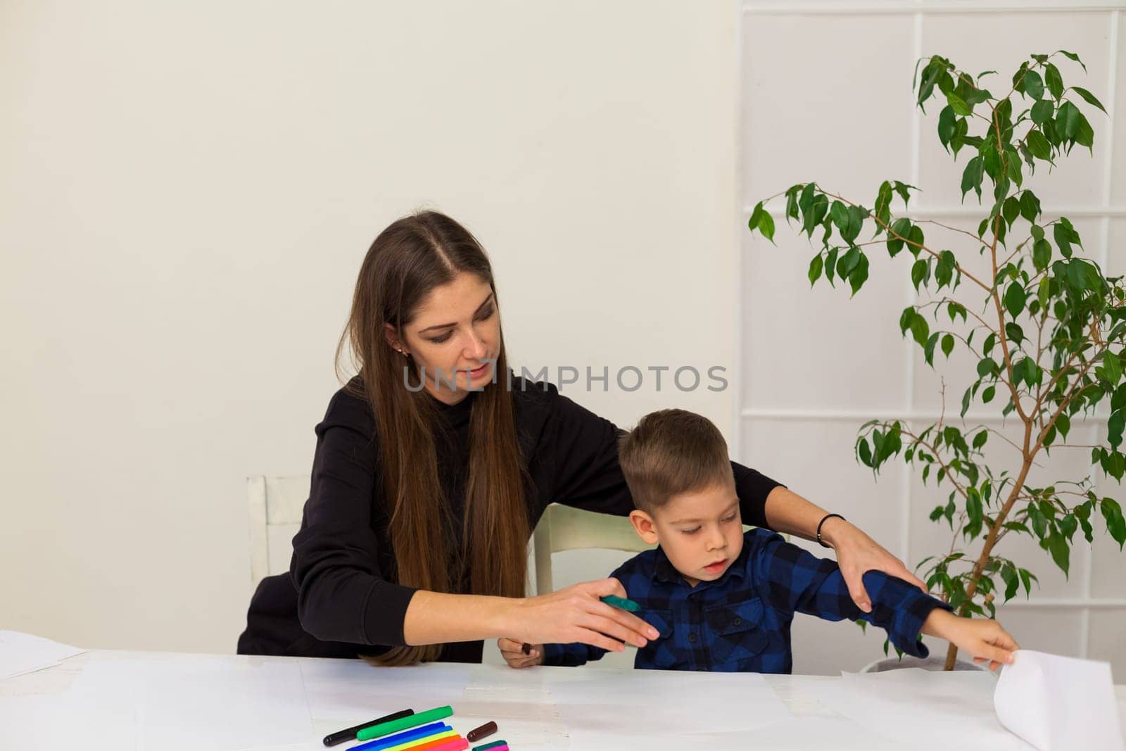 Mom and son learn to draw at table