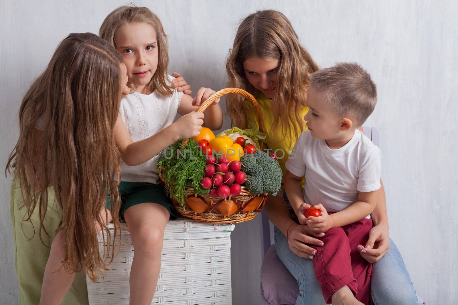 beautiful kids friends family with a basket of ripe vegetables and fruits