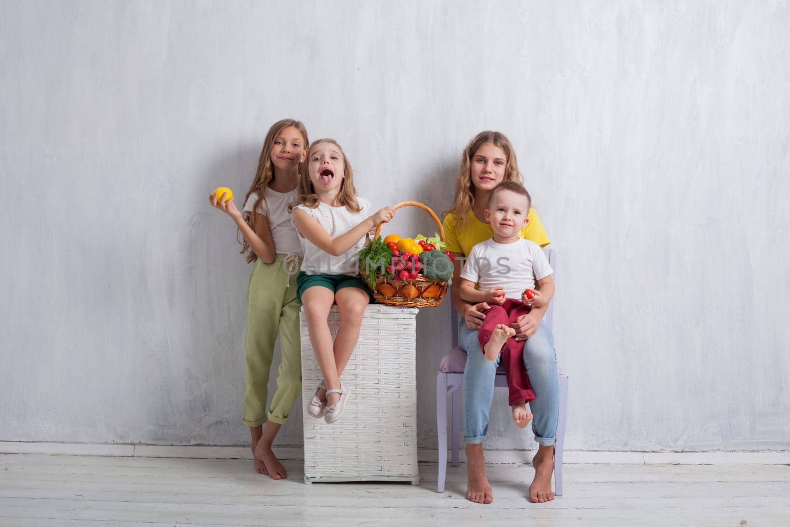 beautiful kids friends family with a basket of ripe vegetables and fruits