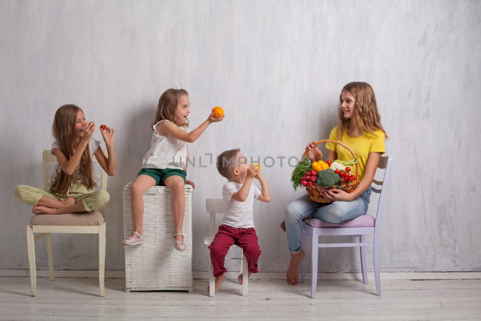 beautiful kids friends family with a basket ofvegetables and fruits by Simakov