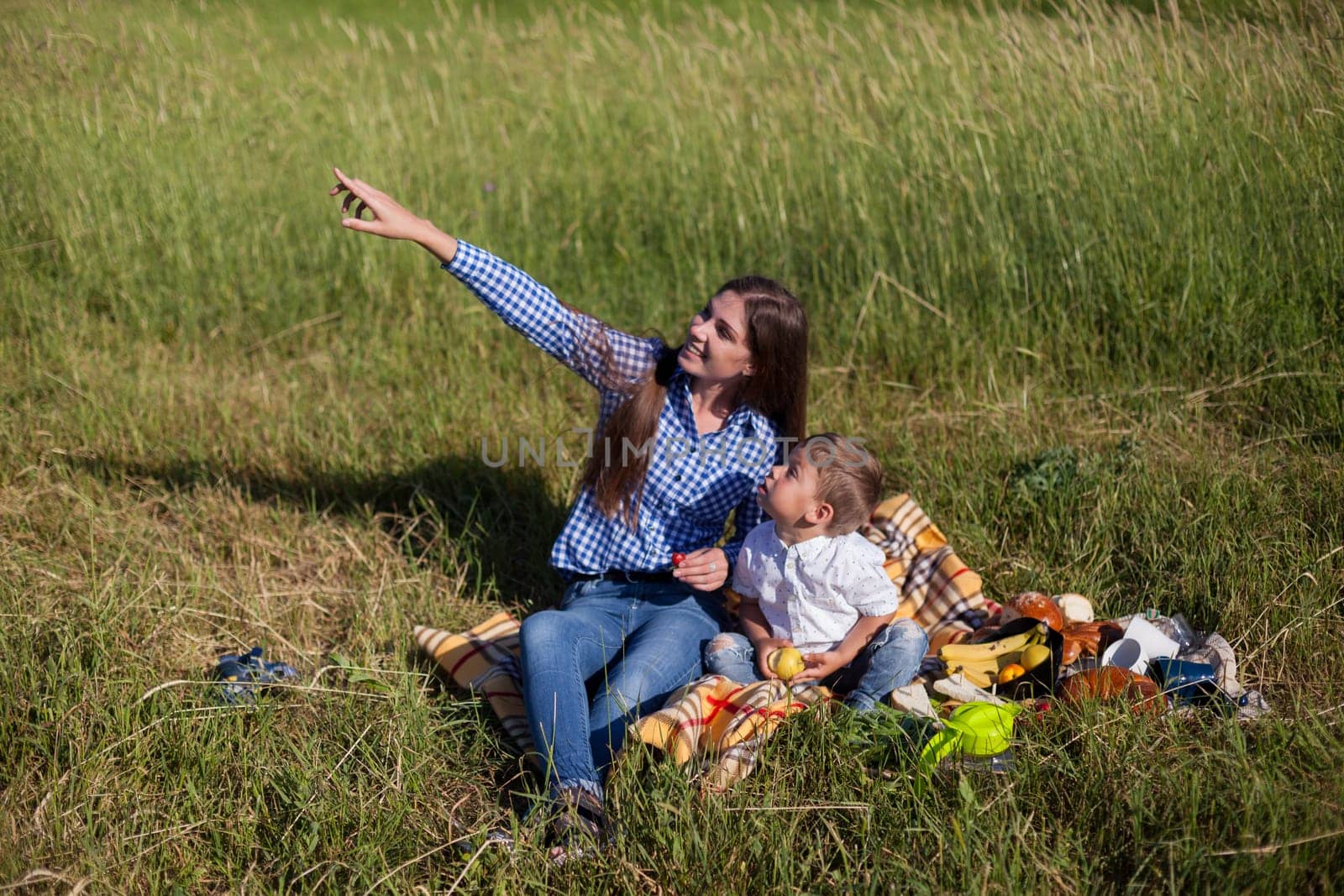 Beautiful woman with her son on a picnic by Simakov