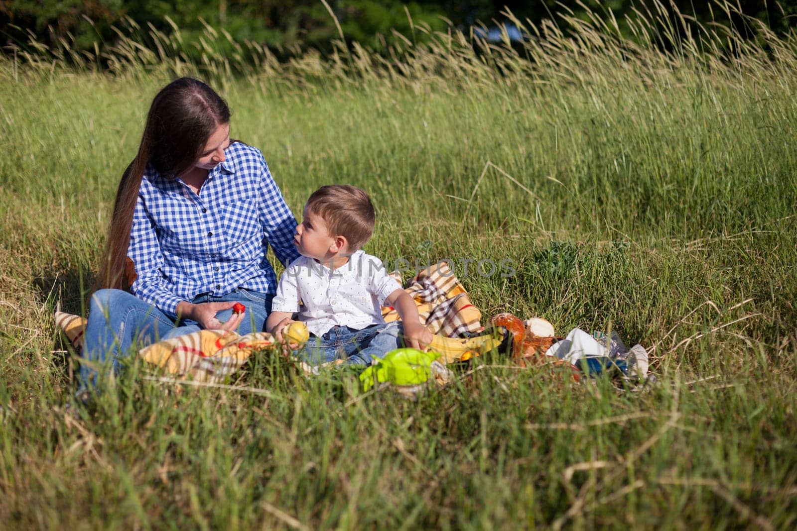 Beautiful woman with her beloved son on a picnic in the woods