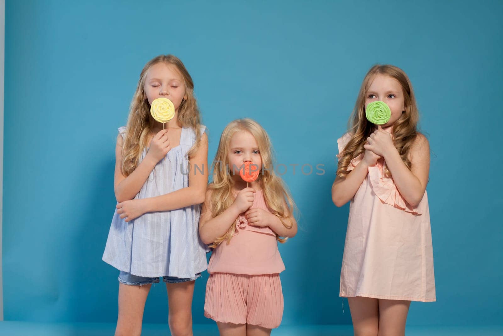 Two little fashionable girlfriend girls with sweet candy by Simakov