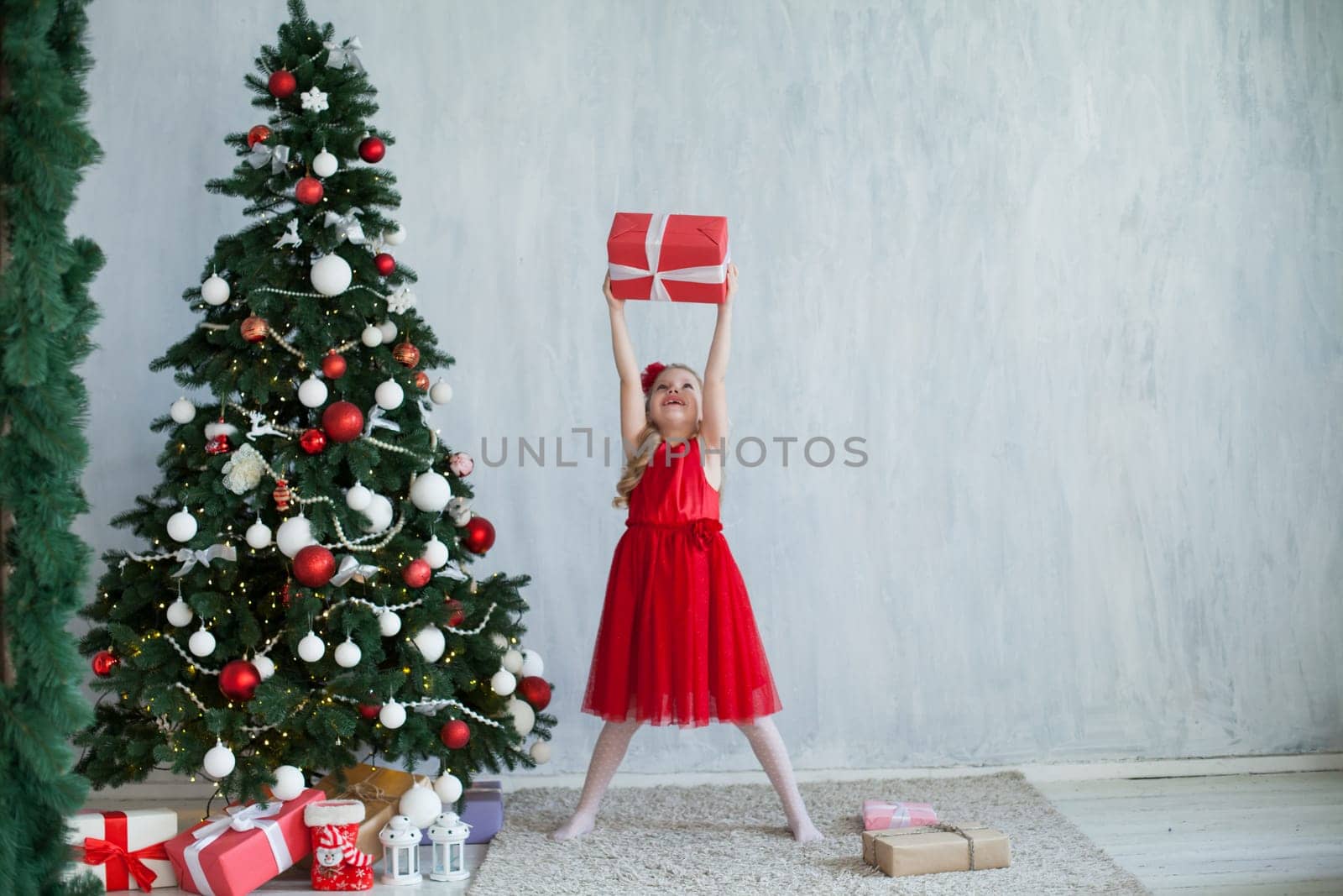 Little girl opens gifts at Christmas tree new year