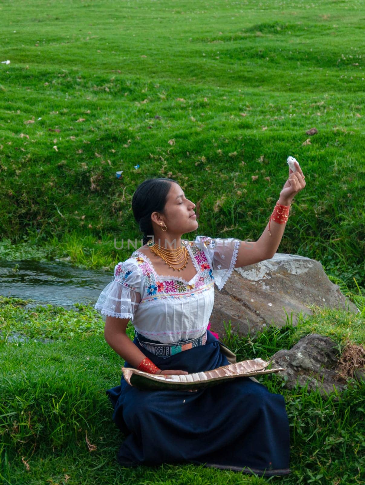 young indigenous girl making an offering to mother nature of the first guaba of the year's harvest, guaba day by Raulmartin