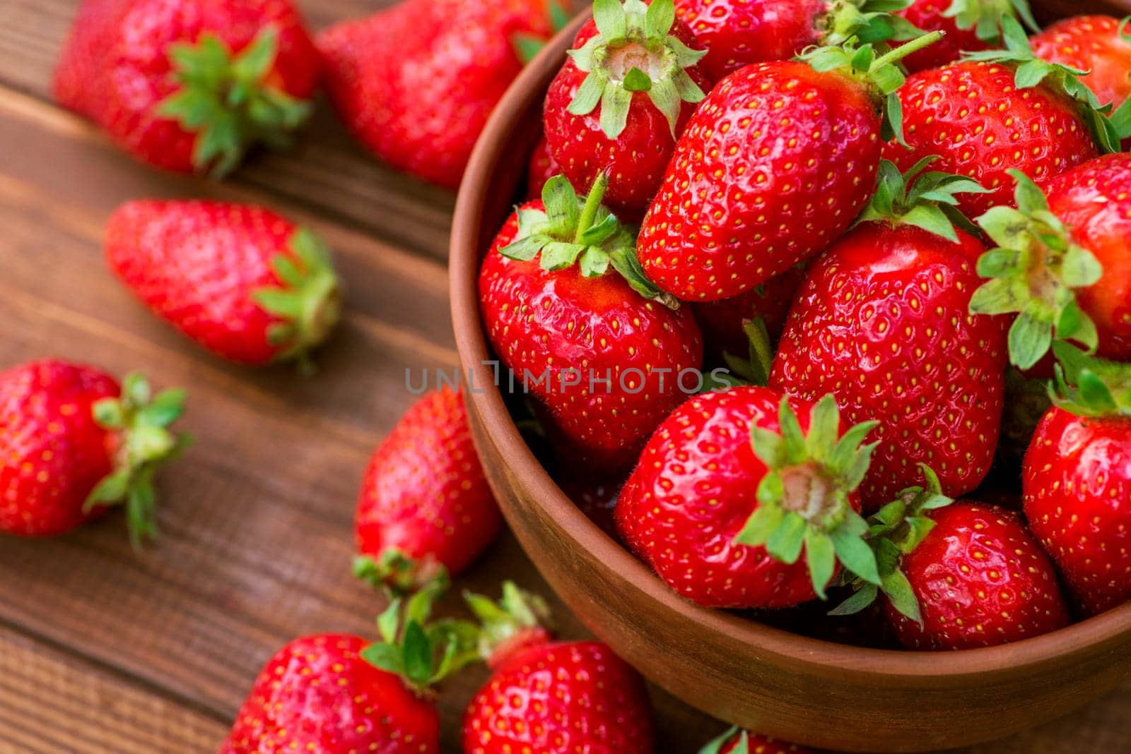 Fresh strawberries in a bowl on wooden table. Strawberry in a Bowl. Top view.