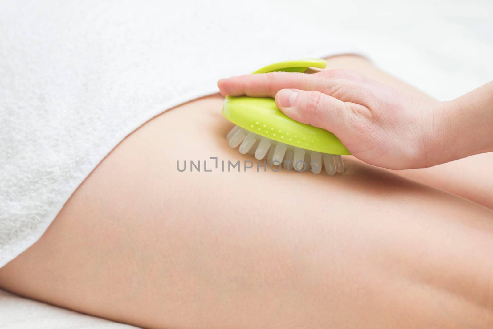 Masseur makes anticellulite massage young woman using massager. Massage with massager to prevent cellulite.