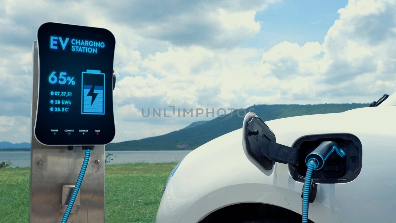 Electric car plugged in with charging station with nature background. Peruse by biancoblue