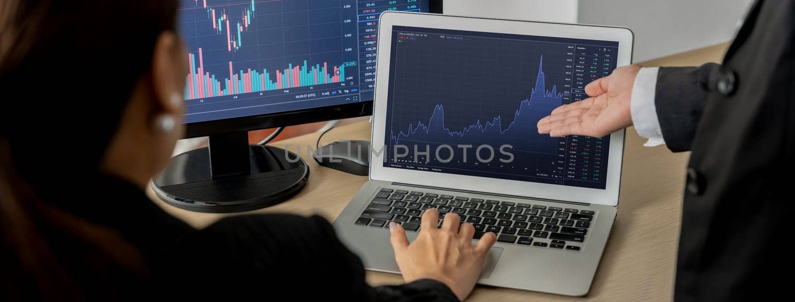 A cropped image of skilled businessman analysis financial stock graph while pointing at display. Stock broker present stock graph to smart businesswoman. Stock investment concept. Burgeoning.