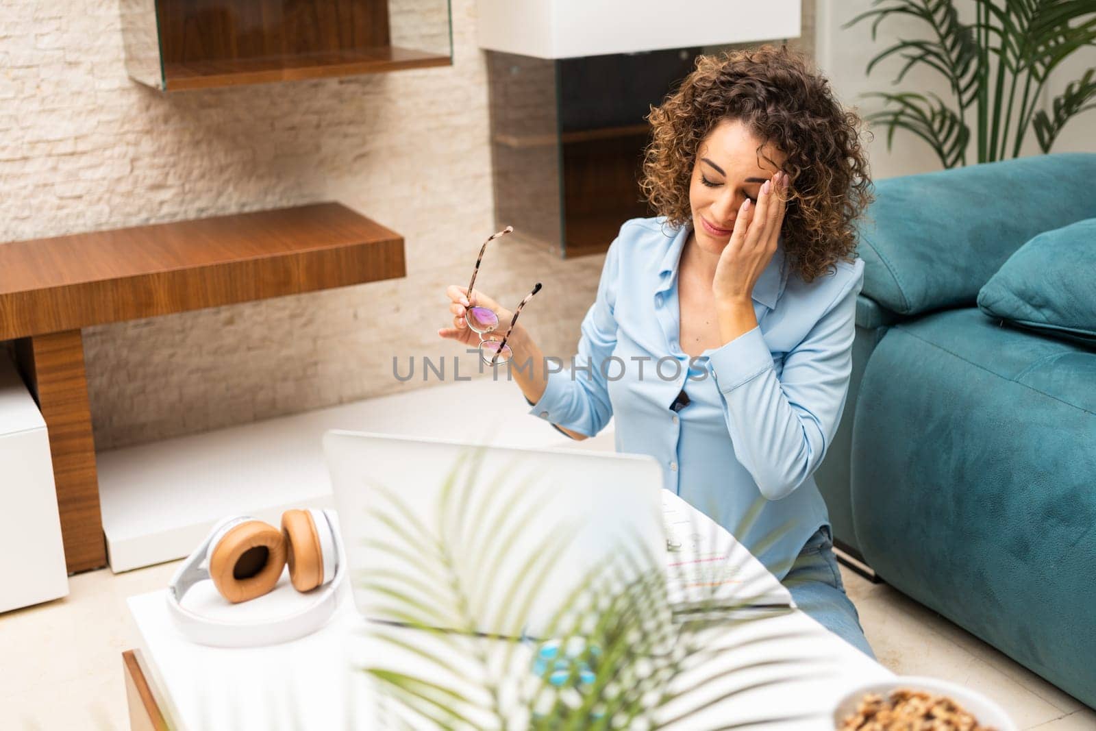 Exhausted woman with laptop in living room at home by javiindy