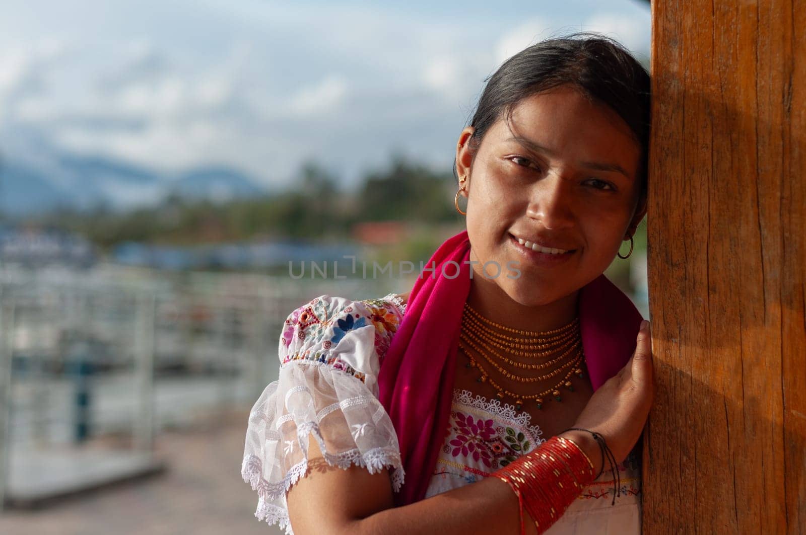 indigenous woman from Otavalo, Ecuador leaning on her wooden house smiling and happy looking at the camera with her traditional outfits and dress. High quality photo
