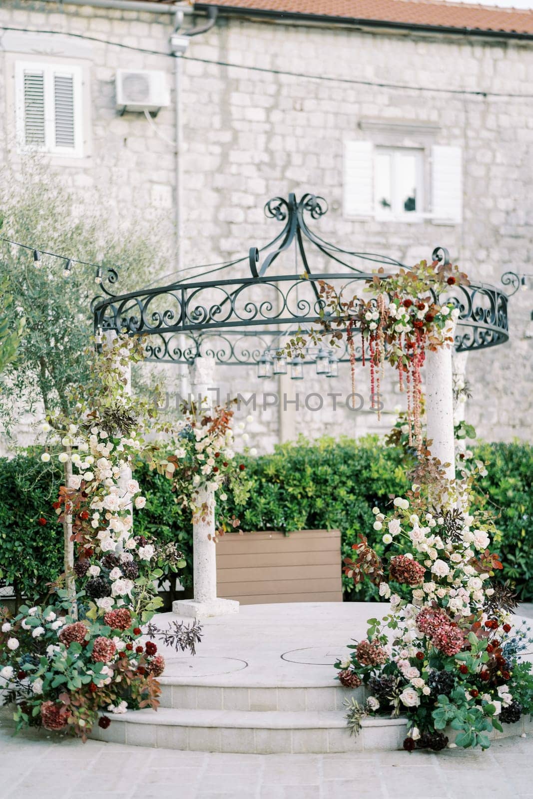 Wedding rotunda decorated with flowers in the courtyard of an ancient house. High quality photo