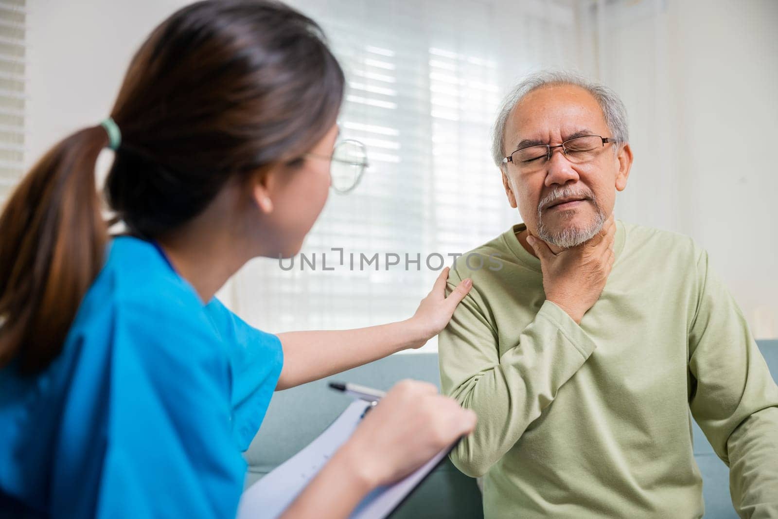 Asian young nurse checking senior man neck pain in clinic at retirement home, doctor woman examines lymph nodes on neck to determine if swollen, sore throat