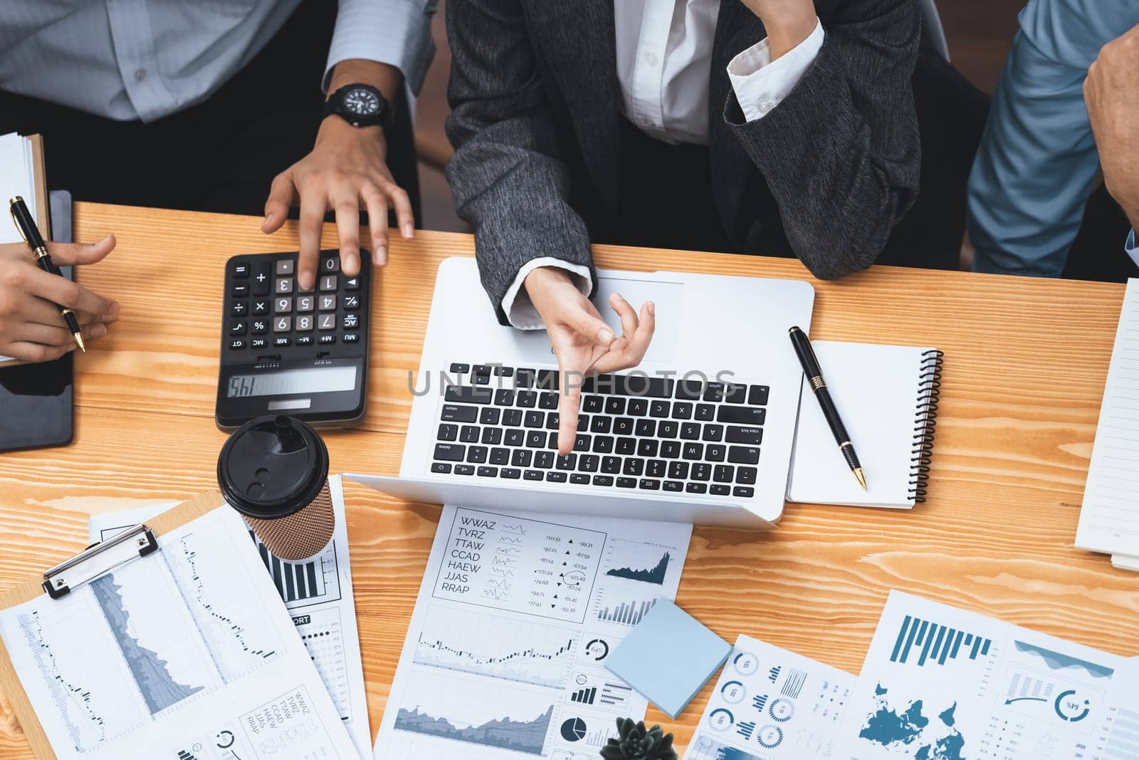 Top view multiracial analyst team use BI dashboard data to analyze financial report on meeting table. Group of diverse business people utilize data analysis by FIntech for business decision. Concord