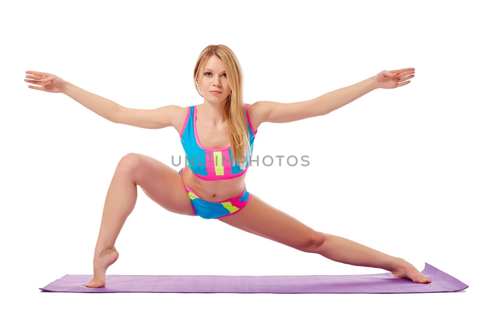 Flexible blonde warming up looking at camera, isolated on white