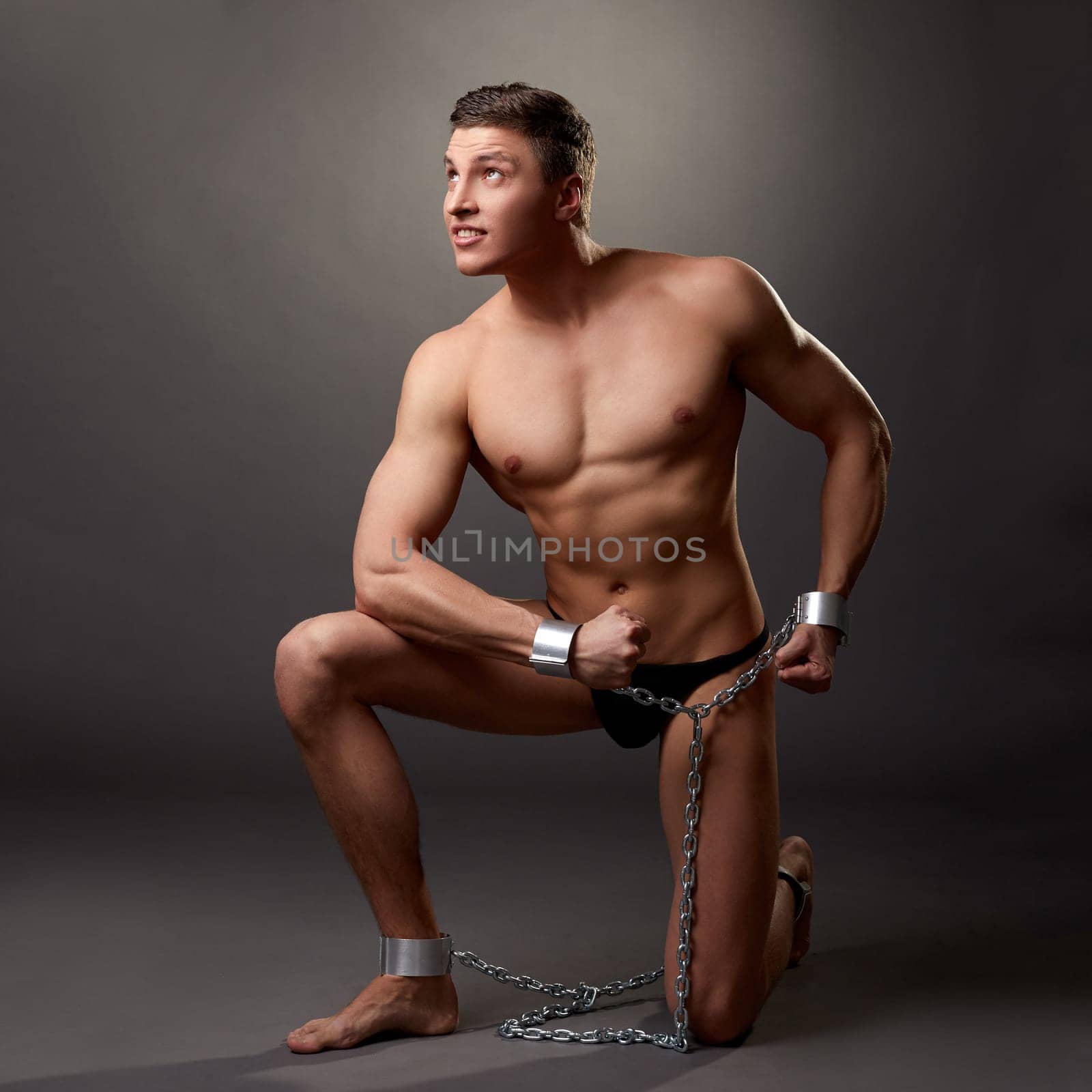 Sexy bodybuilder posing in handcuffs by rivertime