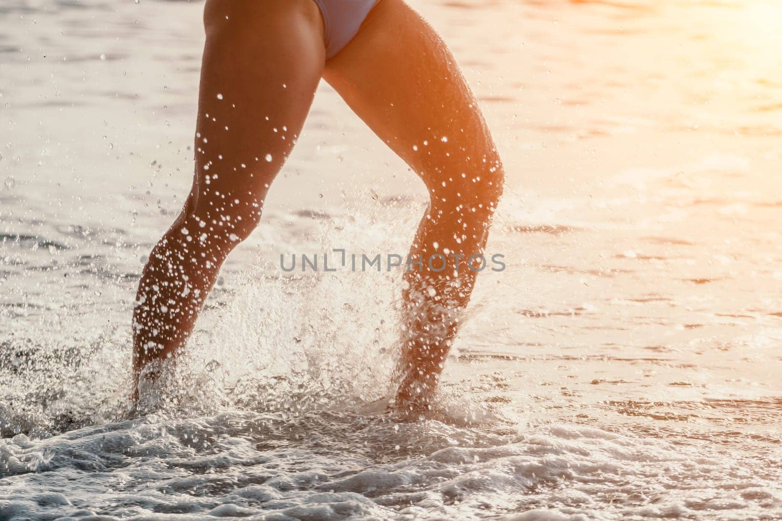 Running woman on a summer beach. A woman jogging on the beach at sunrise, with the soft light of the morning sun illuminating the sand and sea, evoking a sense of renewal, energy and health. by panophotograph