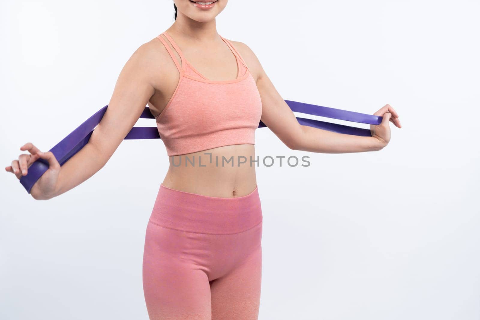 Vigorous energetic woman in sportswear portrait stretching resistance sport band. Young athletic asian woman strength and endurance training session workout routine concept on isolated background.