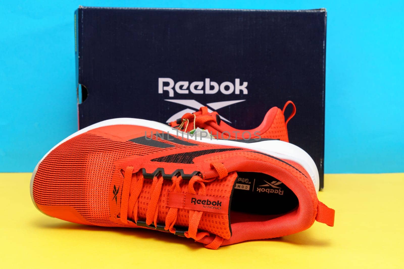 Tyumen, Russia-August 03, 2023: Modern red Reebok sneakers on the yellow and blue background. Nanoflex TR V2.