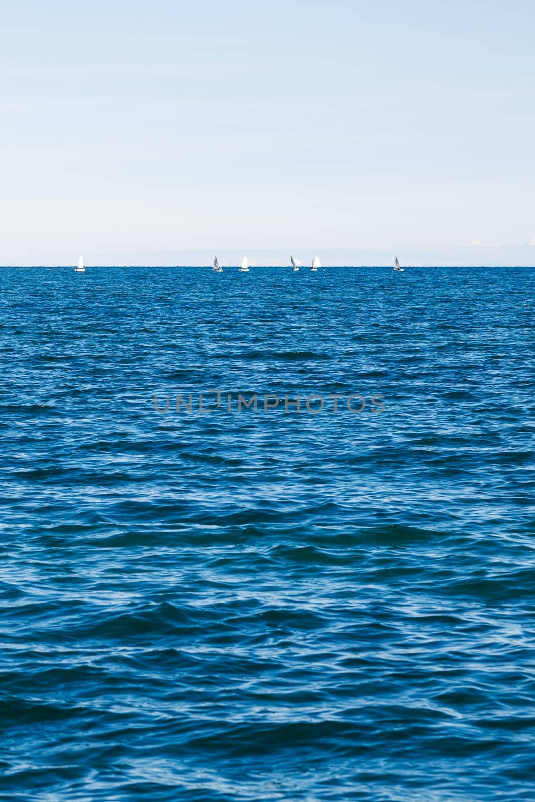 group of sailing boats on Issyk-Kul lake in Kyrgyzstan at sunny autumn afternoon