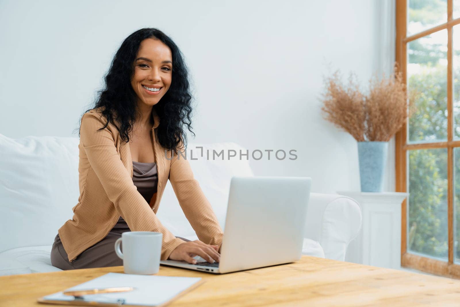 African-American woman using laptop computer for crucial work on internet. Secretary or online content writing working at home.