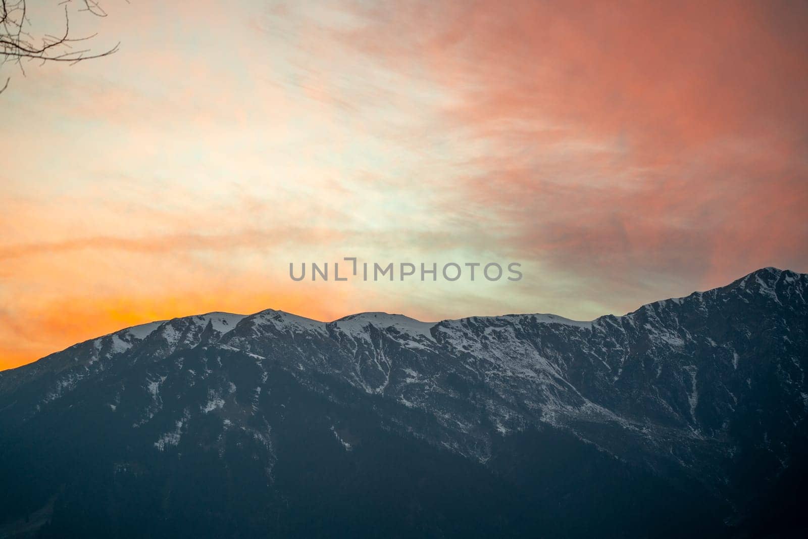 Sunrise sunset dusk dawn colors over the himalaya mountains with fog haze in distance with rich orange and red colors in manali kullu shimla by Shalinimathur