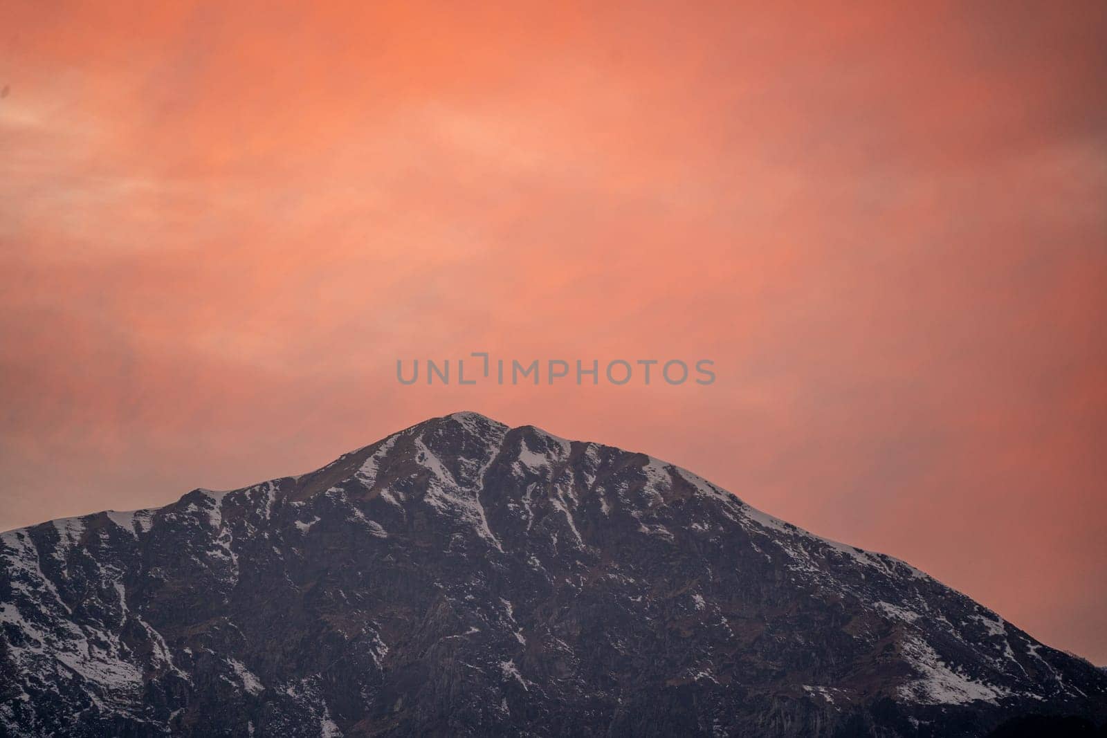 red orange dusk dawn colors over snow covered himalaya mountains and fluffy clouds showing hill stations in jhibbi kullu manali by Shalinimathur