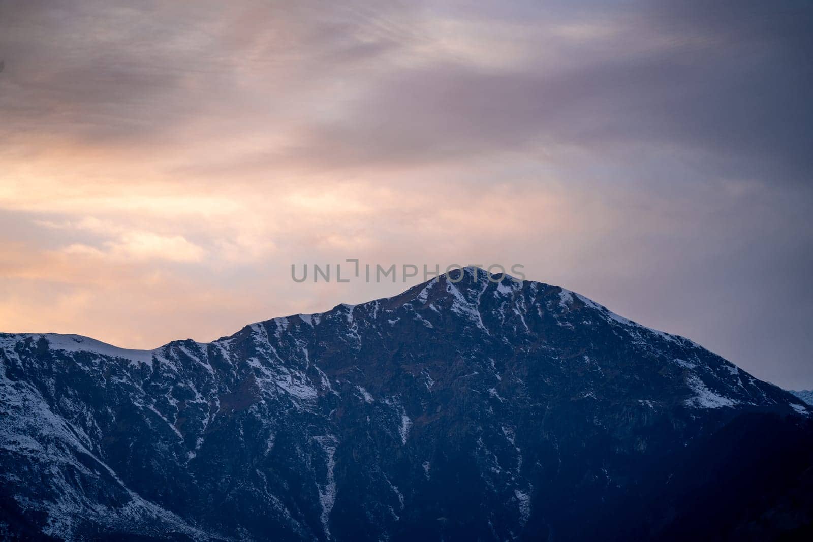 red orange dusk dawn colors over snow covered himalaya mountains and fluffy clouds showing hill stations in jhibbi kullu manali India