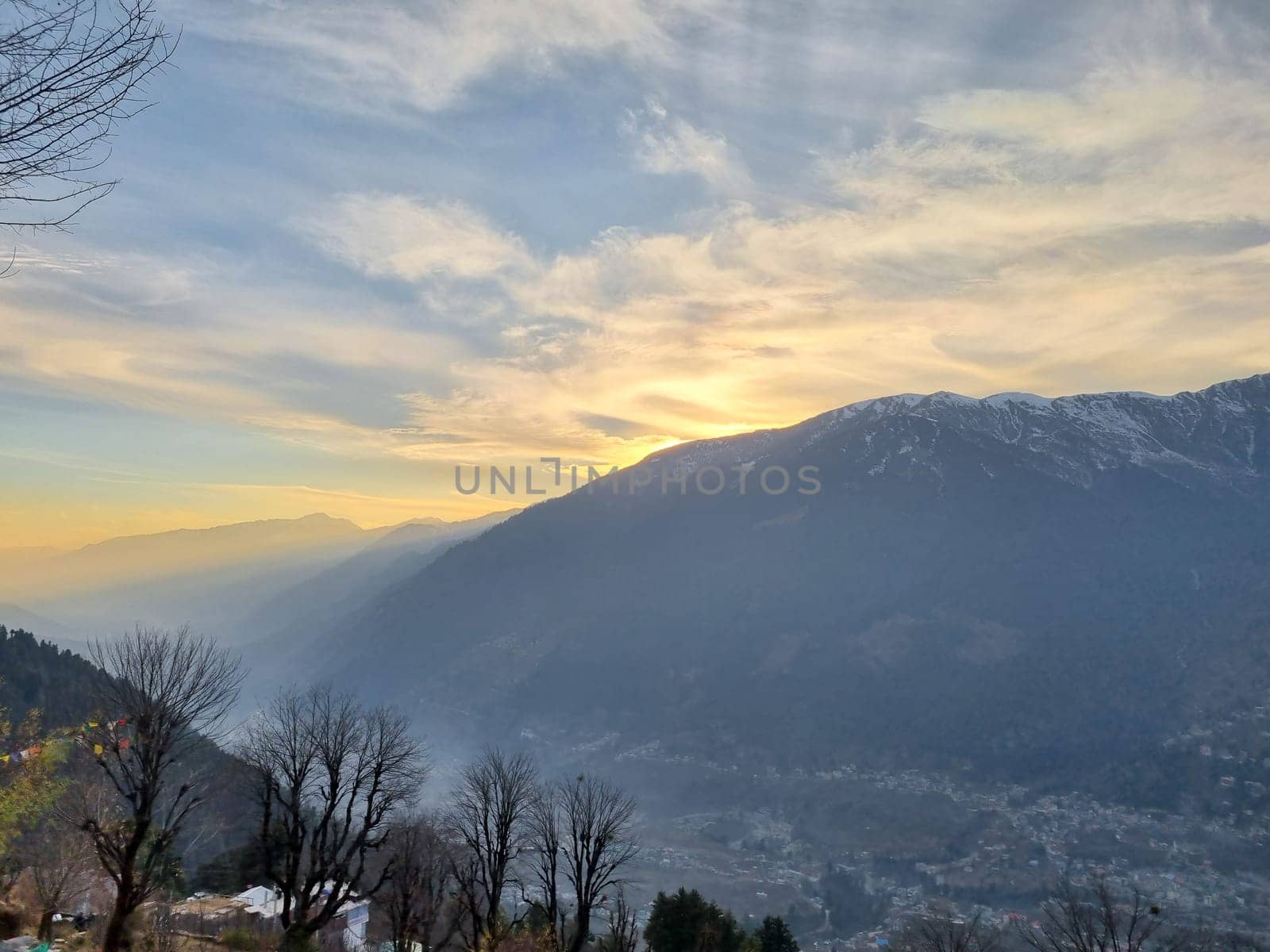 Sunrise over the himalaya mountains with manali kullu valley and clouds with trees in foreground in India