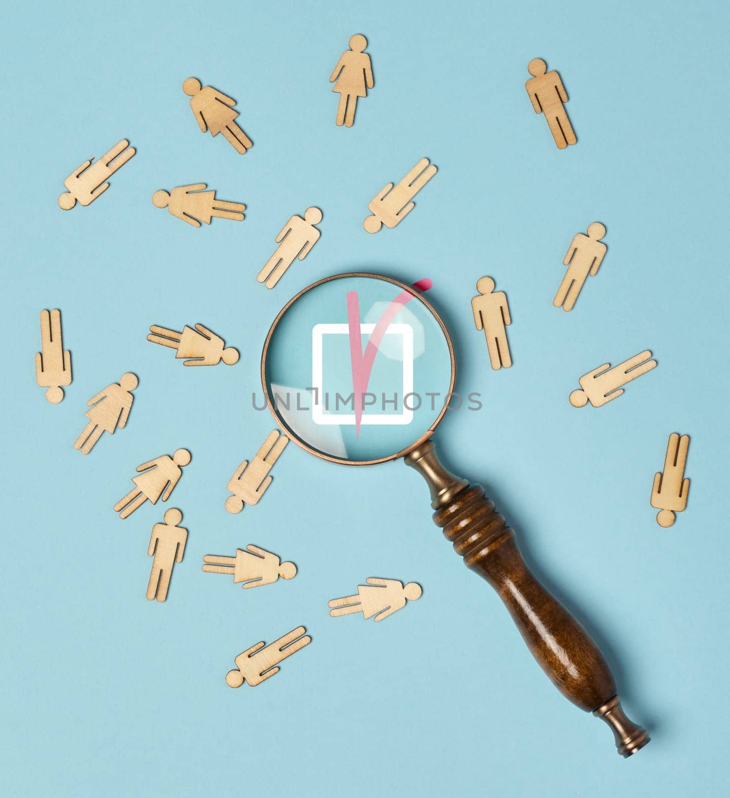 Wooden men and a magnifying glass on a blue background. Recruitment concept, search for talented  by ndanko