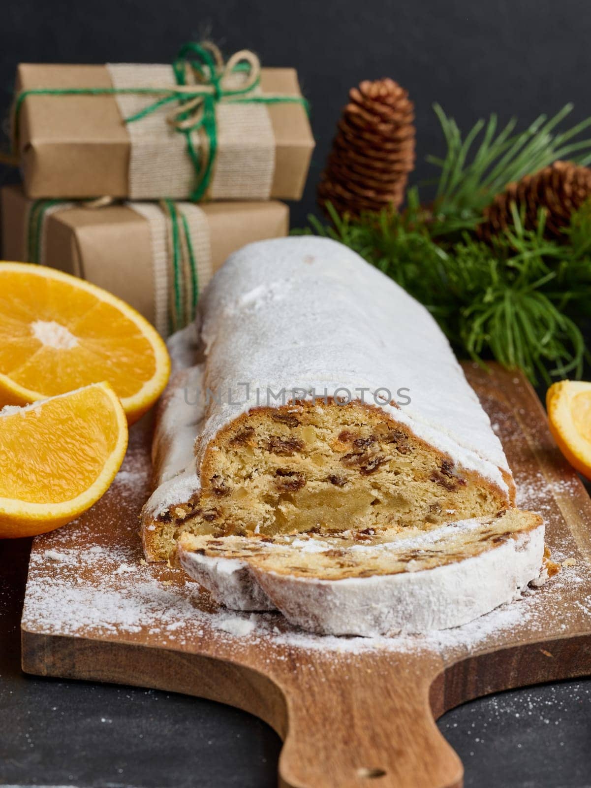 Christmas pastries stollen sprinkled with powdered sugar on the table, festive dessert by ndanko