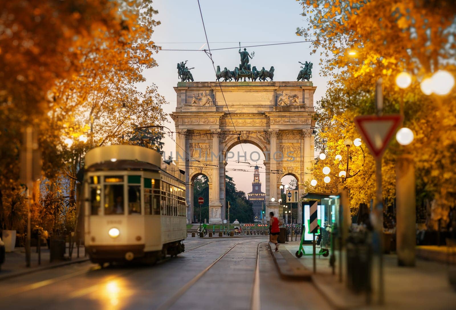 View of the Peace Arch with yellow tram in Milan, Italy