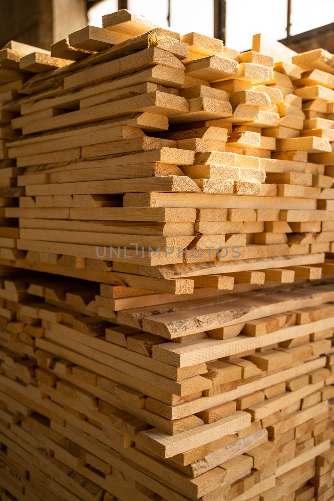 Wood processing. Stacked wooden boards at lumber warehouse in a woodworking industry. Stacks with pine lumber. Raw wood drying in the lumber warehouse