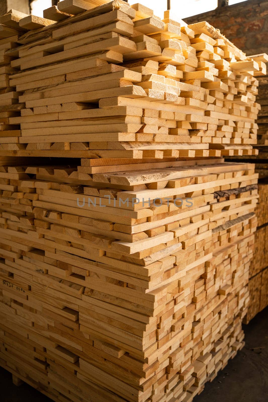 Stacked wooden planks. Hardware store or construction site. Wood for house construction. Building material. Wood warehouse. Wood industry