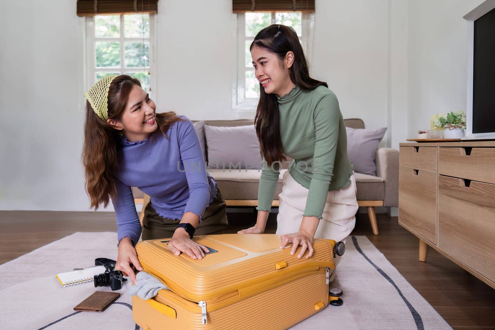 Woman and friend packing a suitcase for a new travel trip. bag and luggage for journey.