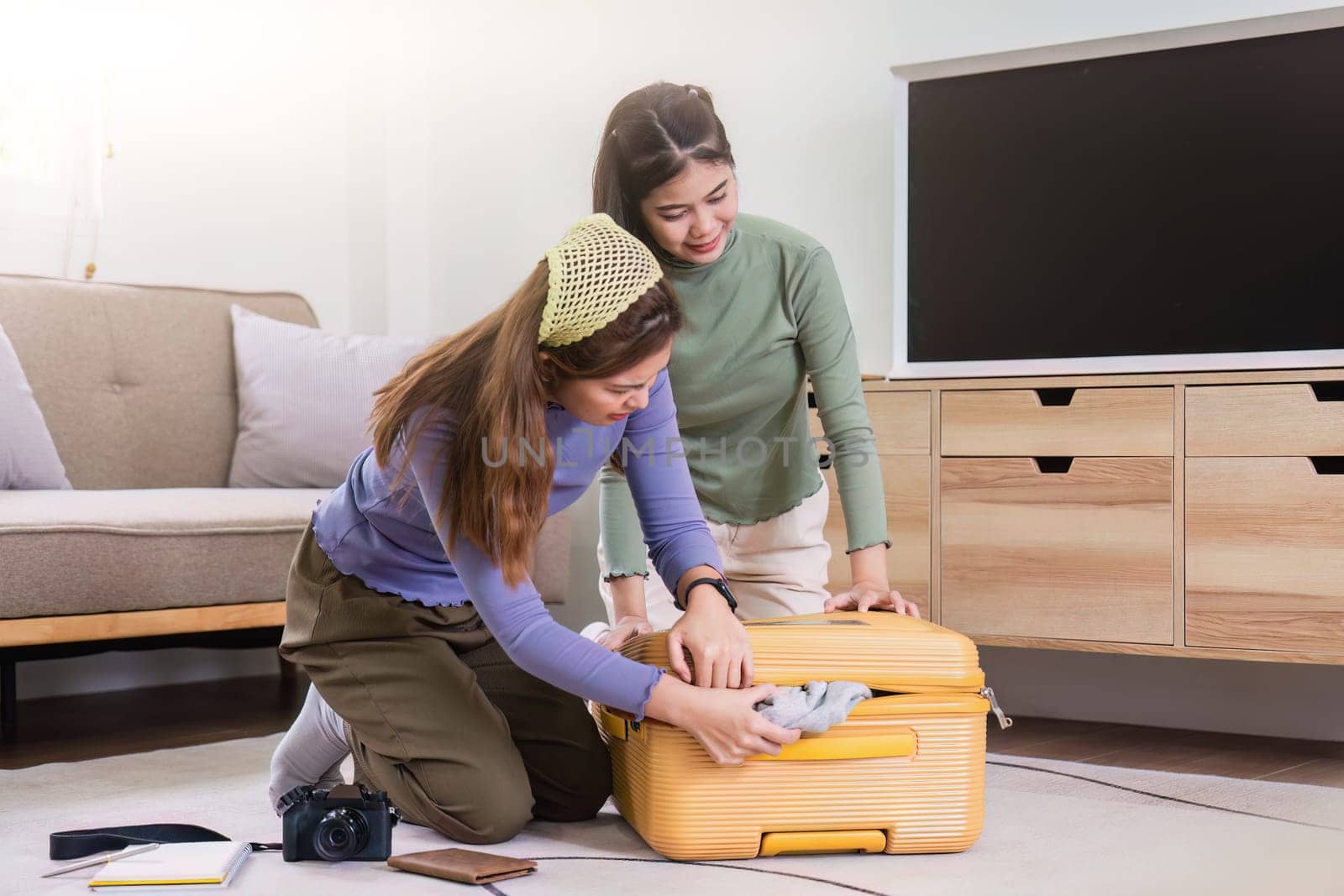 Woman and friend packing a suitcase for a new travel trip. bag and luggage for journey.