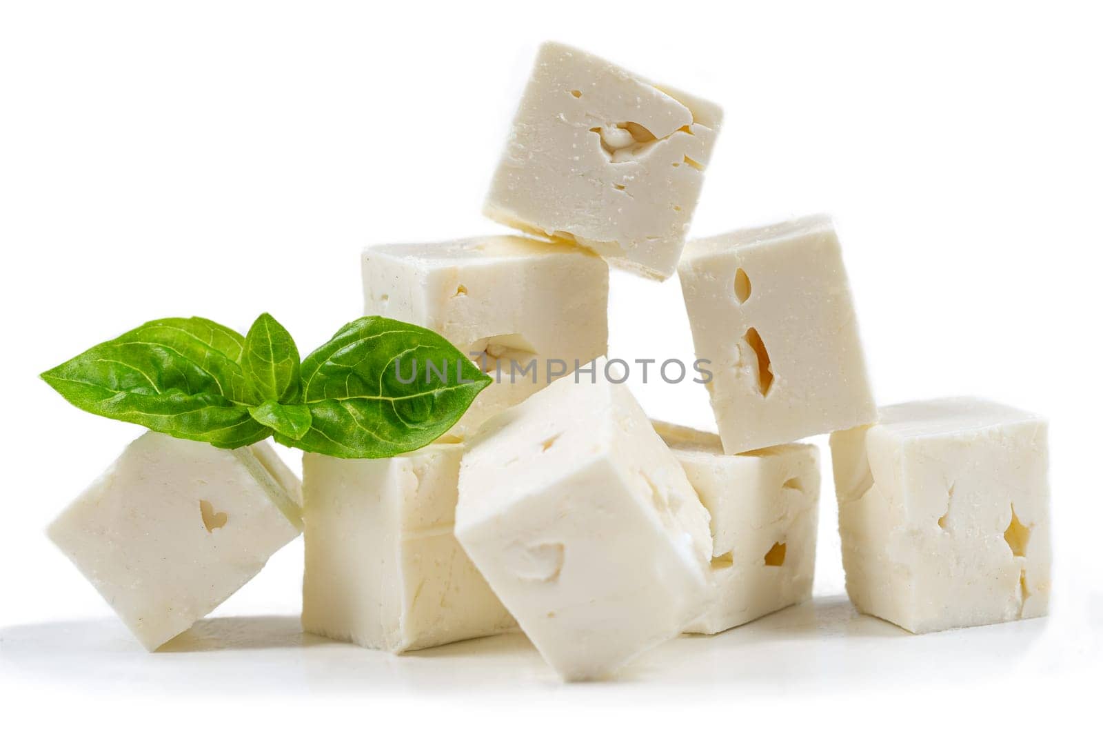 Cube Feta cheese isolated on white background clipping Heap of Feta cheese, basil leaves and tomatoes. by JPC-PROD