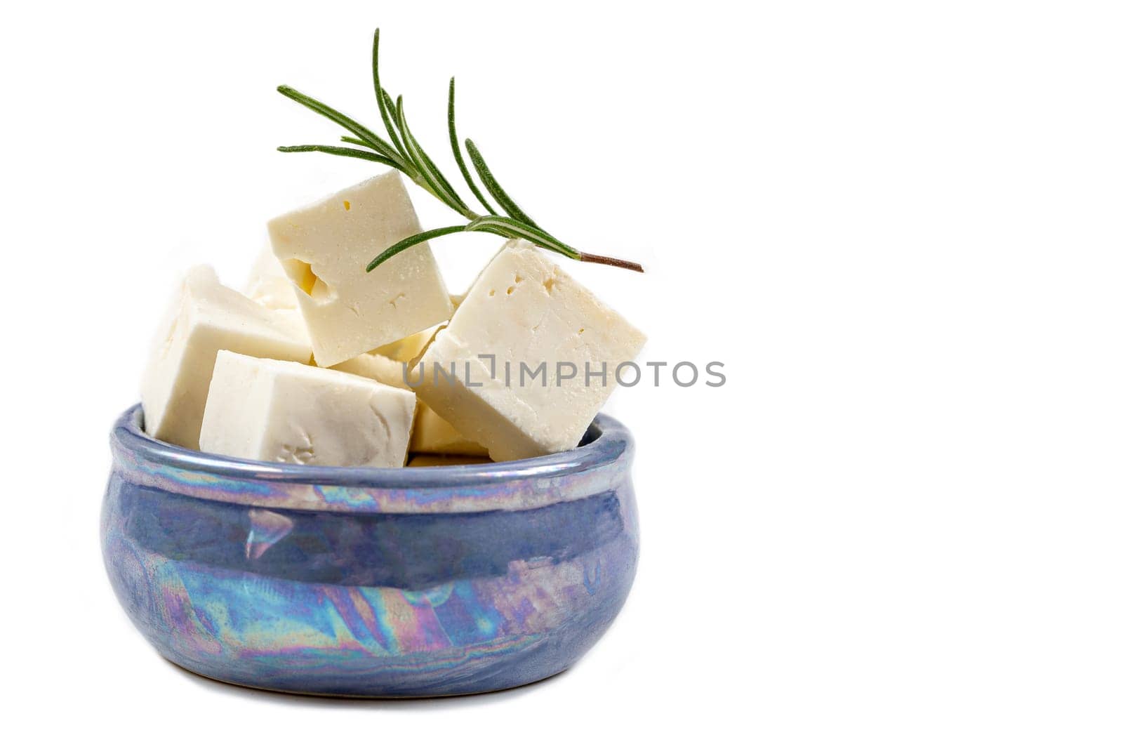 Feta cheese cubes isolated on white background with clipping path. Heap of Feta cheese, basil leaves and tomatoes.